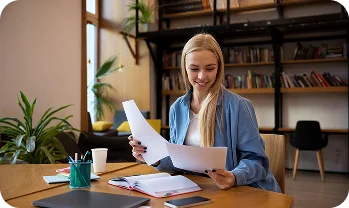 Une jeune femme avec des documents, illustrant le soutien apporté par l'entreprise dans la collecte de documents importants, l'enregistrement et le passage des contrôles dans une nouvelle ville ou un nouveau pays.